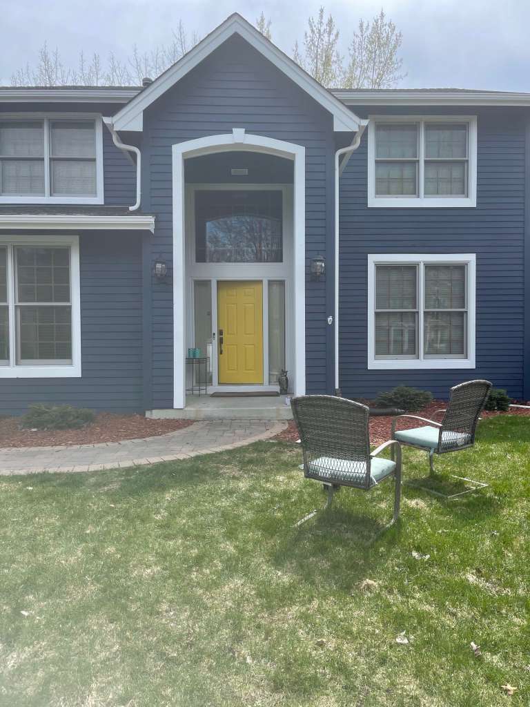 Navy blue home with yellow door after painting